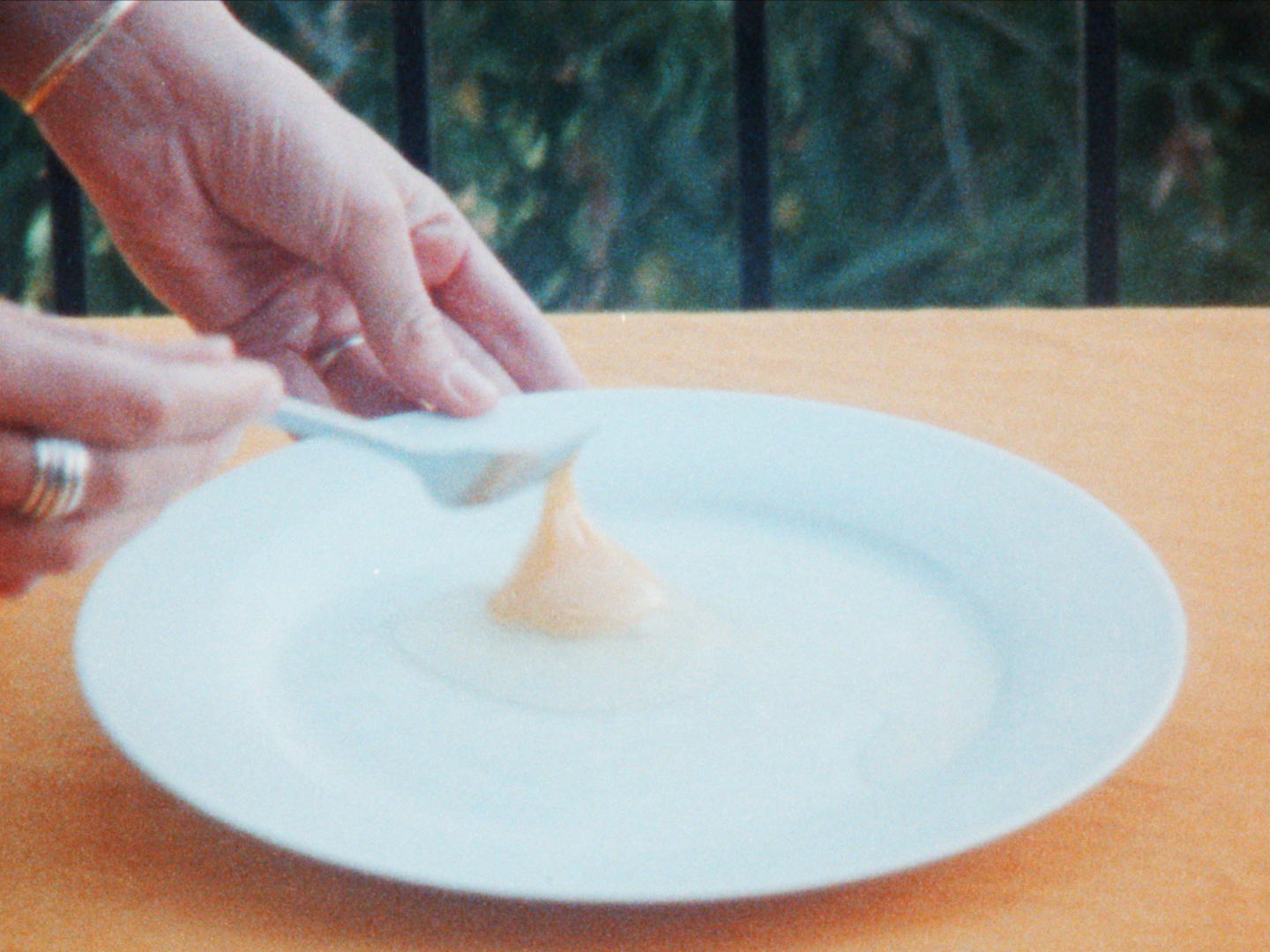 hand whisking egg on yellow table